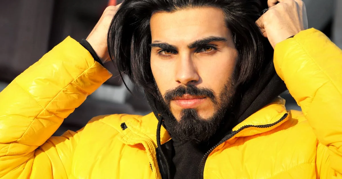 Portrait en gros plan d'un homme ajustant sa veste jaune avec confiance.